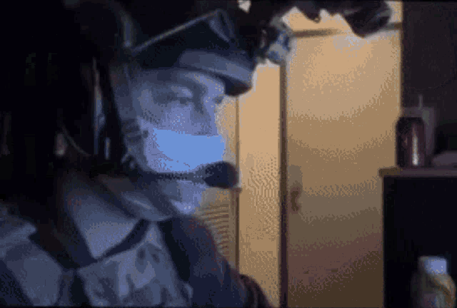 a man wearing a mask and a headset looks at something