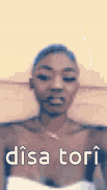 a woman in a white dress is making a funny face with the words disa tori written on her chest .