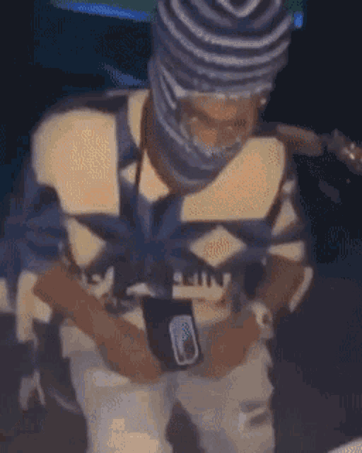 a man wearing a beanie and a mask is sitting down .