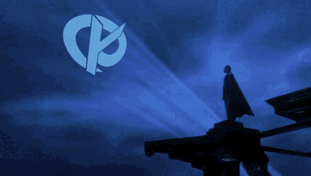 a man in a cape stands on top of a building in front of a blue sky with a circle with the letter p on it