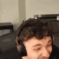 a man wearing headphones is smiling while sitting in a chair