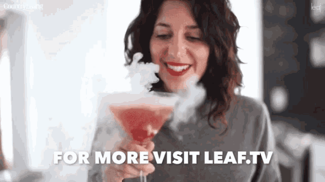 a woman is holding a martini glass with smoke coming out of it and the words for more visit leaf.tv below her