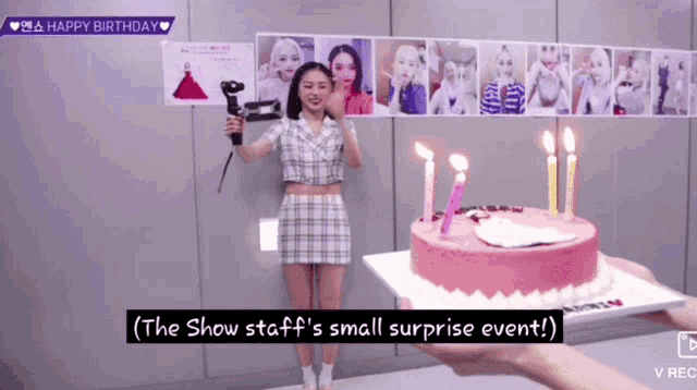 a woman holding a hair dryer in front of a birthday cake