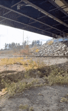 a bridge over a train track has graffiti on the side of it