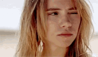 a close up of a woman 's face with her eyes closed and a slight smile on her face .