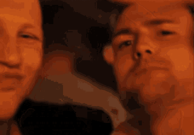 a blurry picture of two men 's faces with one making a face
