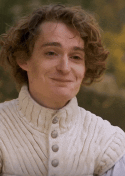 a young man with curly hair is wearing a white vest with buttons