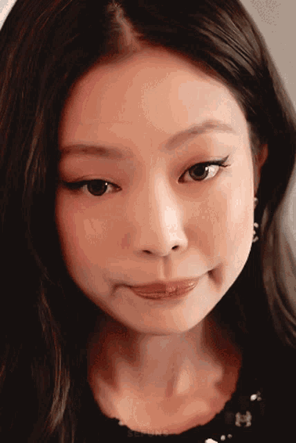 a close up of a woman 's face with the letter h on the bottom