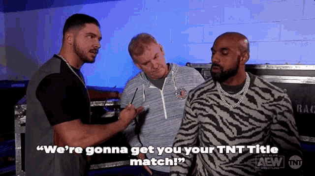 three men are standing next to each other in a room and one of them is wearing a zebra print sweater .