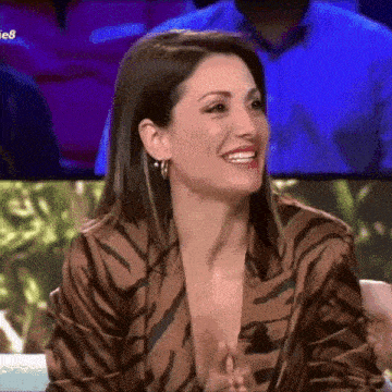 a woman in a zebra print jacket is smiling while sitting on a chair .
