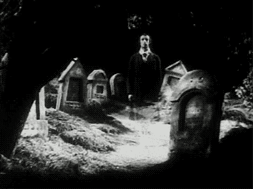 a black and white photo of a cemetery with a ghost standing in the middle of it .