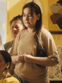 a woman in a tan t-shirt is standing next to another woman in a yellow shirt