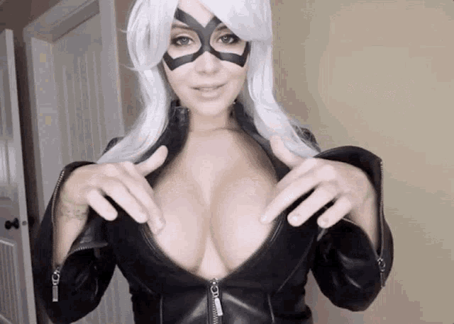 a woman is wearing a black leather jacket and a black mask