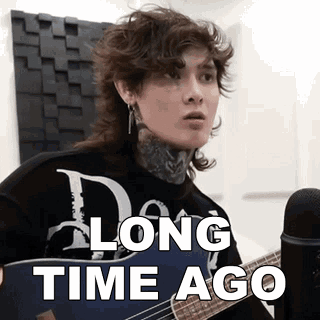 a person holding a guitar with the words long time ago written on it
