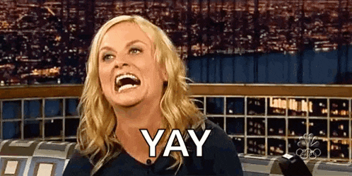 a woman is laughing and saying yay while sitting in front of a microphone .