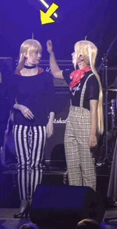 two women are standing next to each other on a stage .