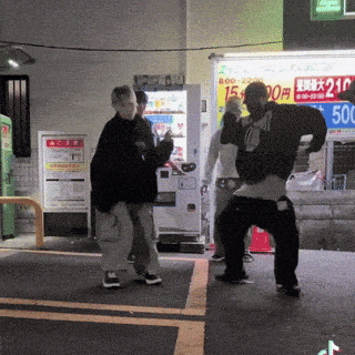 a group of people dancing in front of a vending machine that says 210