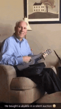 a man is sitting in a chair playing an ukulele with the caption he bought an ukulele in a silent auction