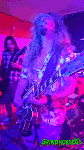 a man playing a guitar in front of a sign that says grim hordes