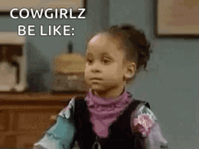 a little girl is sitting at a table with the words `` cowgirlz be like '' written on the screen .