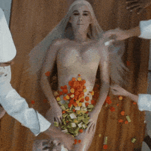a woman is laying on a wooden table with vegetables on her body