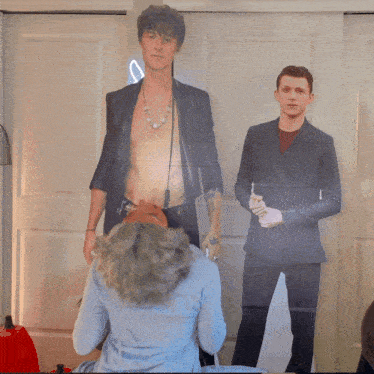 a woman is kneeling down in front of a cardboard cut out of two men