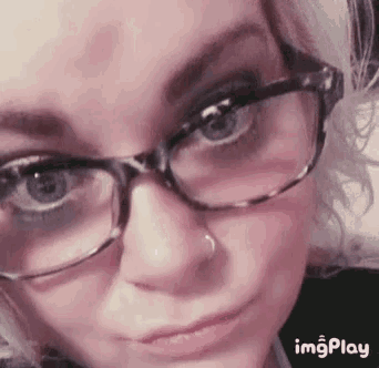 a close up of a woman 's face with glasses and a nose ring with the words imgplay below it