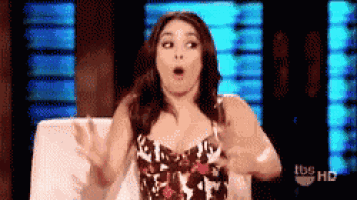 a woman in a floral dress is sitting in a chair with her hands outstretched ..