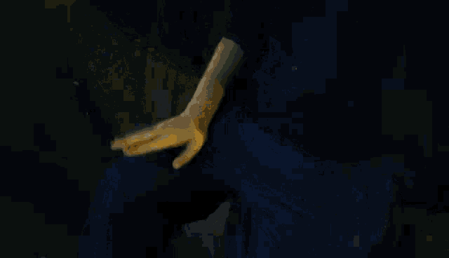 a person wearing gloves sits on a bench with their hand on their lap