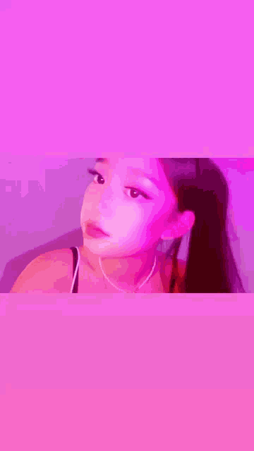 a close up of a woman 's face in front of a pink background .