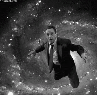 a man in a suit and tie is flying through a galaxy in a black and white photo .