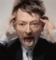 a man in a suit and tie is holding his head .