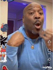 a man wearing a blue shirt and a gold necklace