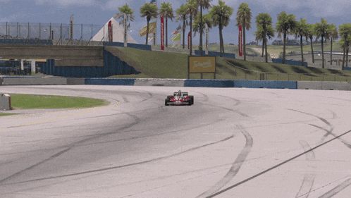 a race car on a track with a sign that says coca cola on it