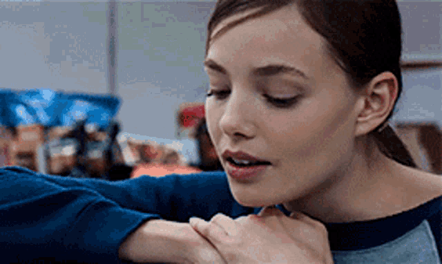 a close up of a woman 's face with a person 's arm around her shoulder