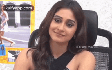 a woman is smiling while sitting in a chair .