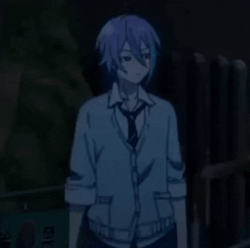 a boy with a cardigan and tie is standing in the dark