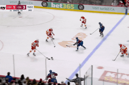 a hockey game is being played in front of an ad for bet365