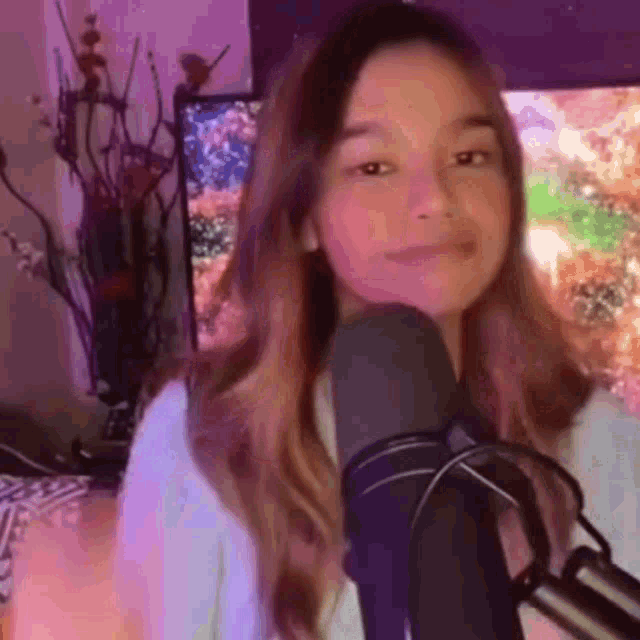 a girl is standing in front of a microphone in a room .
