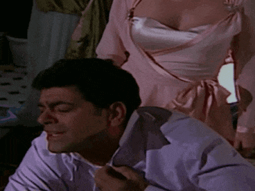 a woman in a pink dress is tying a man 's tie