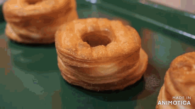 a donut with a hole in it is on a green tray that says made in animatica