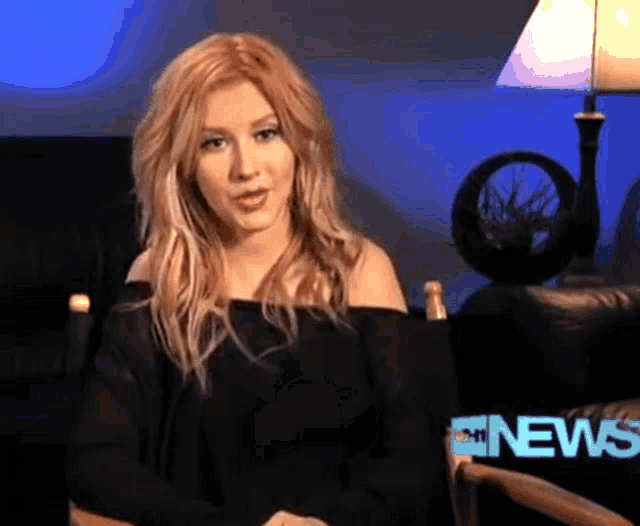 a woman sitting in a chair with the word news behind her