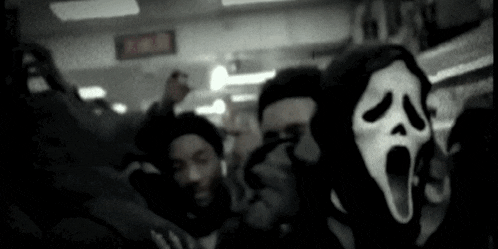 a group of people are wearing scream masks in a dark room