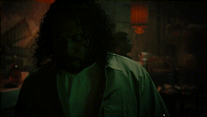 a man standing in a dark room holding a gun