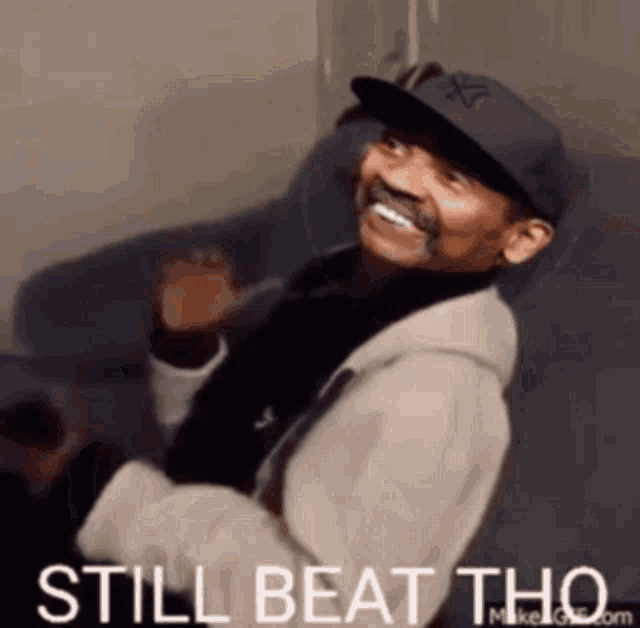 a man sitting on a couch with the words still beat tho written below him