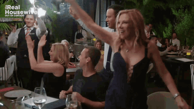 a group of people dancing in a restaurant with a real housewives logo in the background