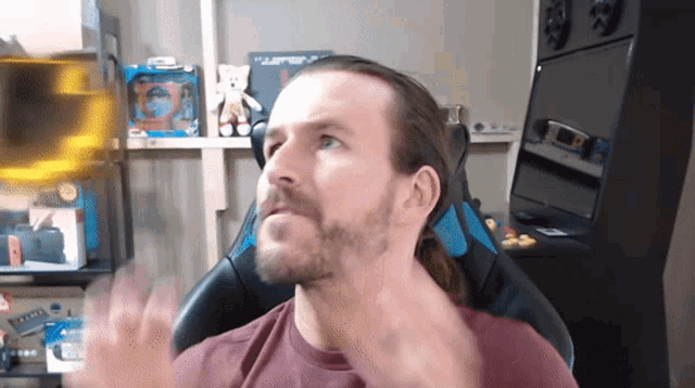 a man with long hair and a beard sitting in a chair