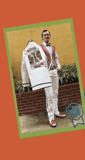 a man in a suit is holding a jacket that says king of hearts on it