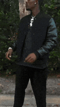a man in a black jacket and black pants is holding a bag of ice cream