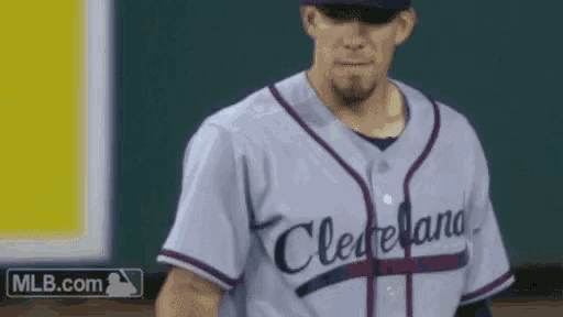 a baseball player wearing a cleveland jersey is walking on the field
